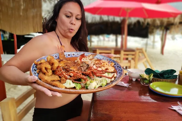 a woman sitting at a table with a plate of food