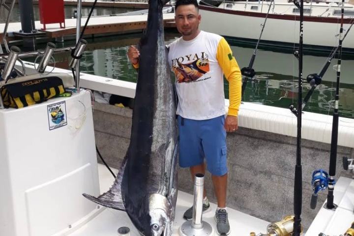 a person holding a fish on a boat