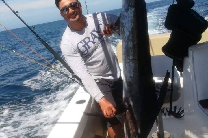 a person holding a fish in the water