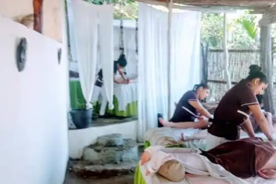 a person sitting on a bed next to a window