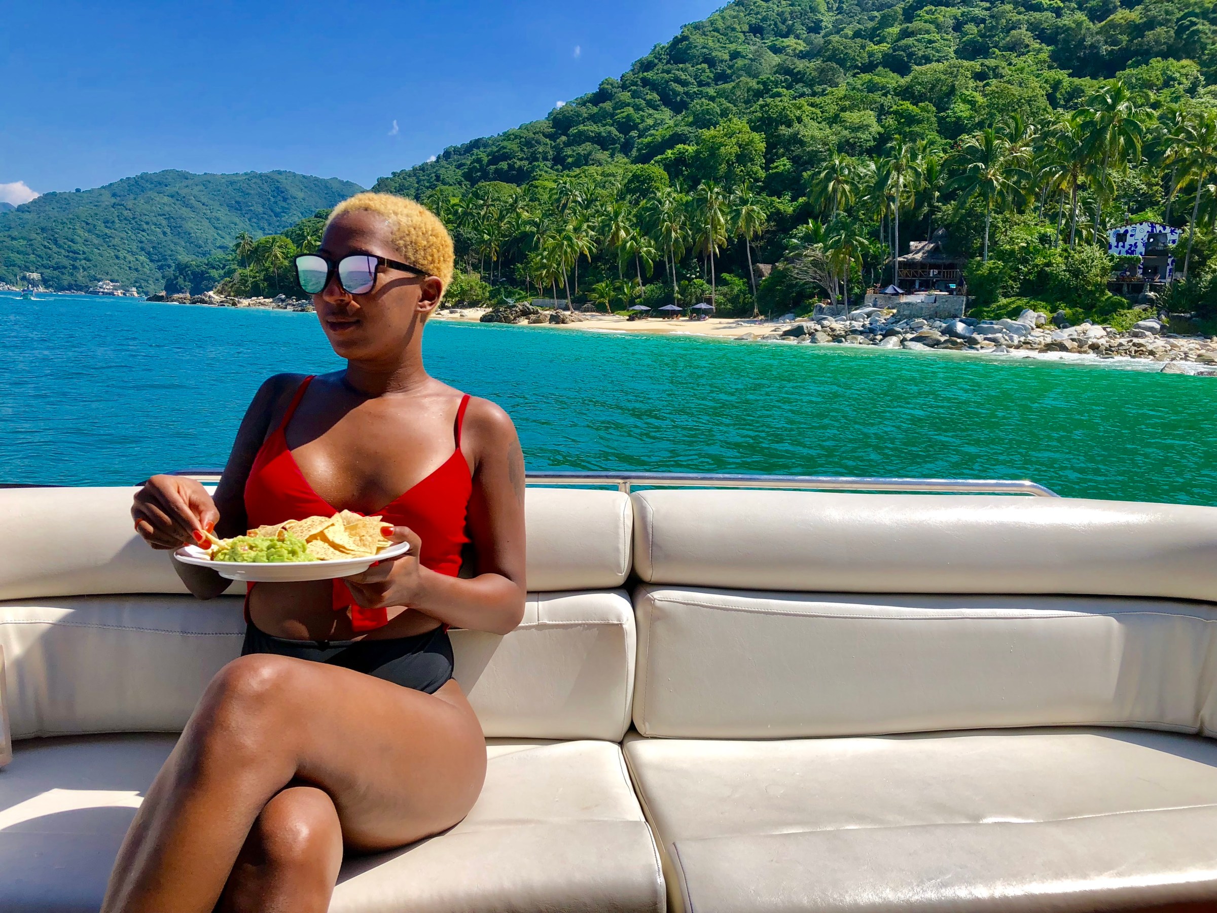 a woman sitting on a bench in front of a lake