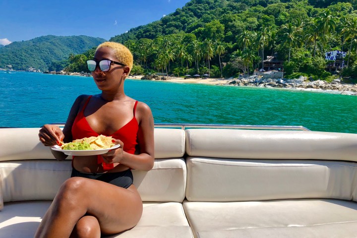 a woman sitting on a bench in front of a lake
