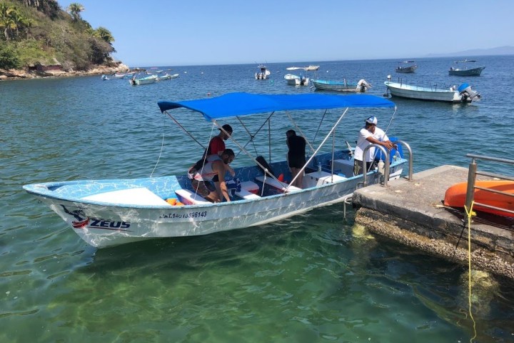 a group of people riding on the back of a boat in the water
