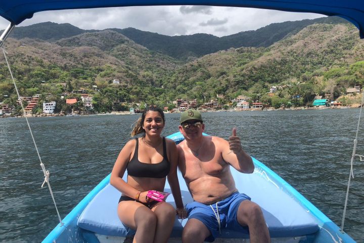 a group of people sitting in a boat on a body of water