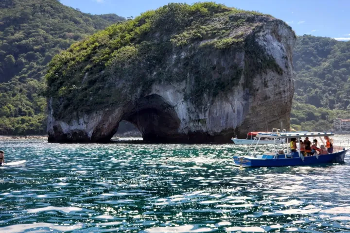 a small boat in a body of water with a mountain in the background
