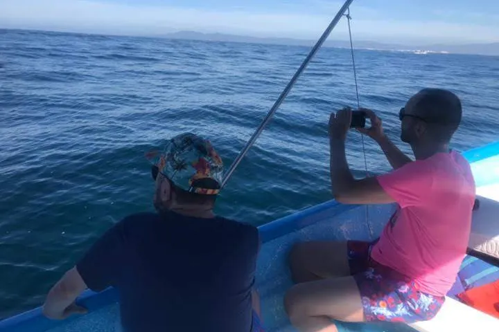a man standing next to a body of water
