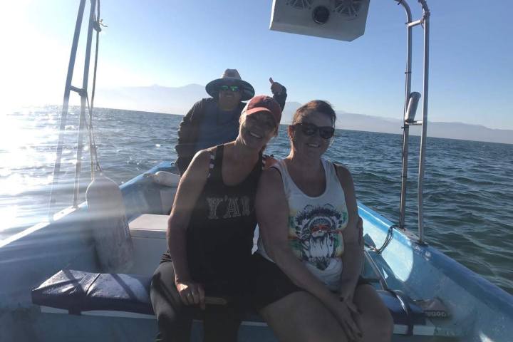 a person standing in front of a boat next to a body of water
