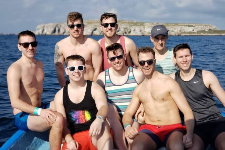 a group of people standing next to a body of water