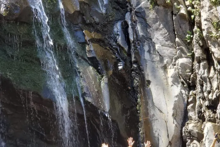a group of people standing next to a waterfall