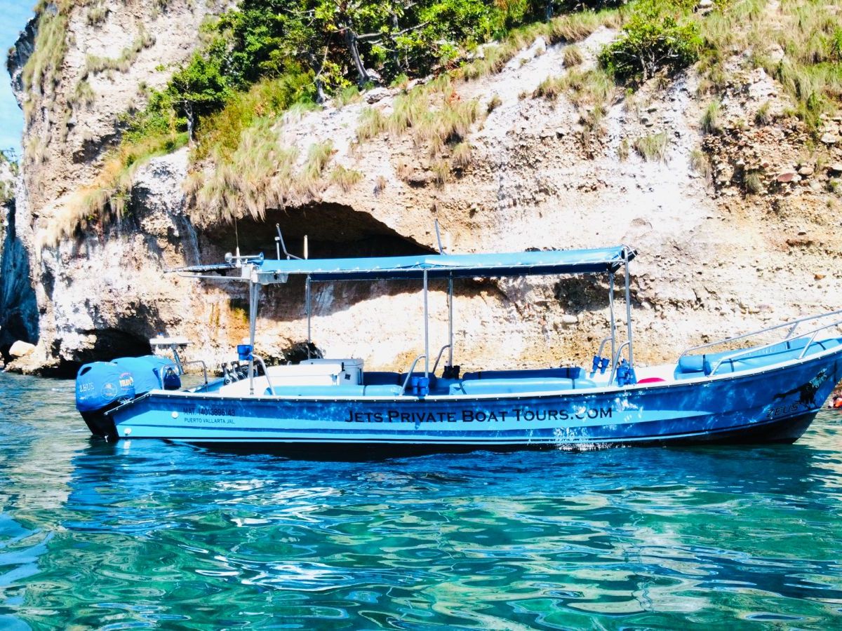 a blue and white boat sitting next to a body of water