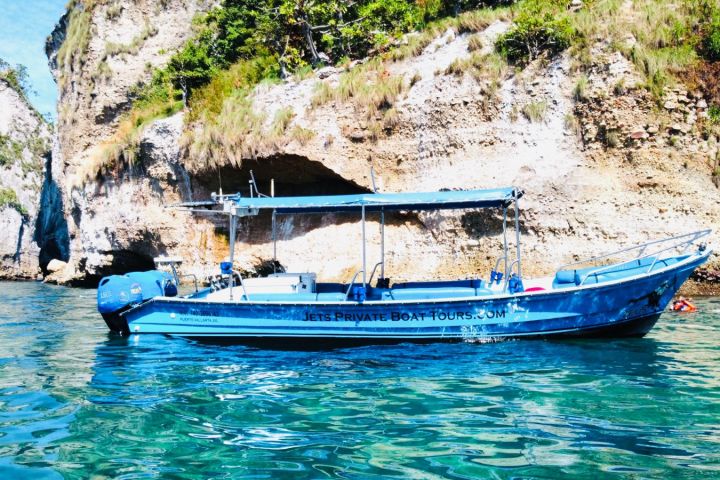 a blue and white boat sitting next to a body of water
