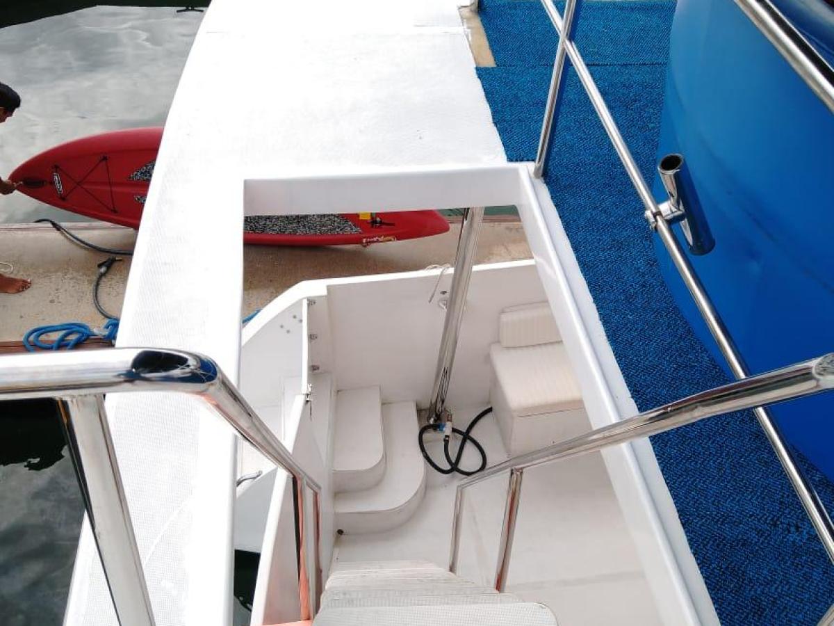 View of boat deck with stairs and railing by the water.
