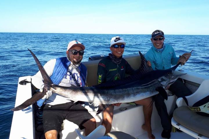 a person holding a fish on a boat in the water