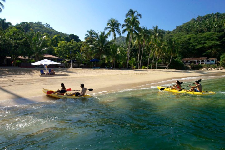 a group of people riding on the back of a boat in the water