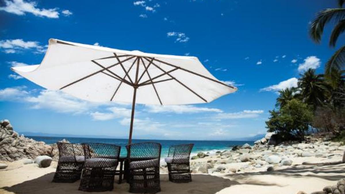 an umbrella sitting on top of a sandy beach
