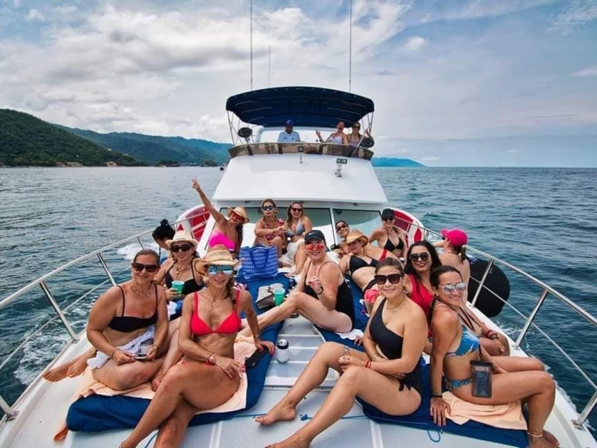 a group of people sitting in a boat on a body of water