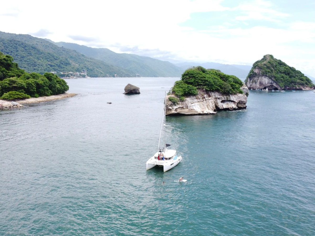 a small boat in a body of water with a mountain in the background