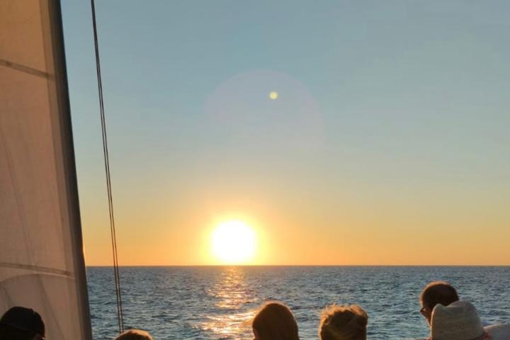 a group of people sitting next to a body of water