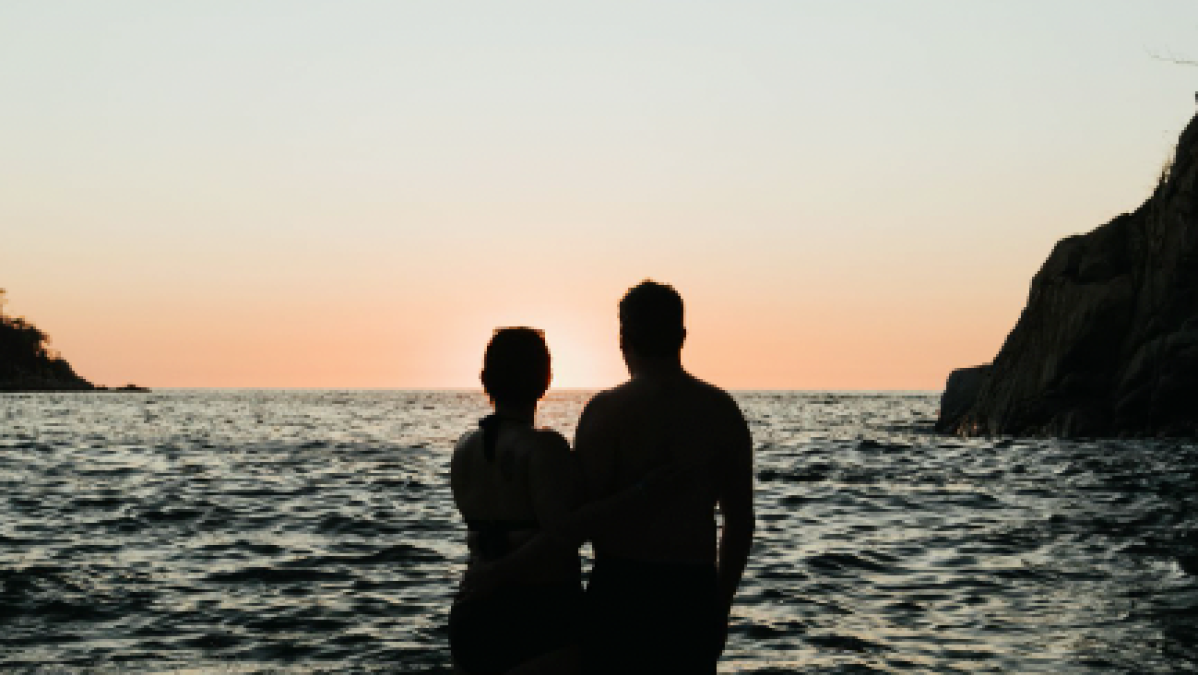 a man standing on a beach near a body of water