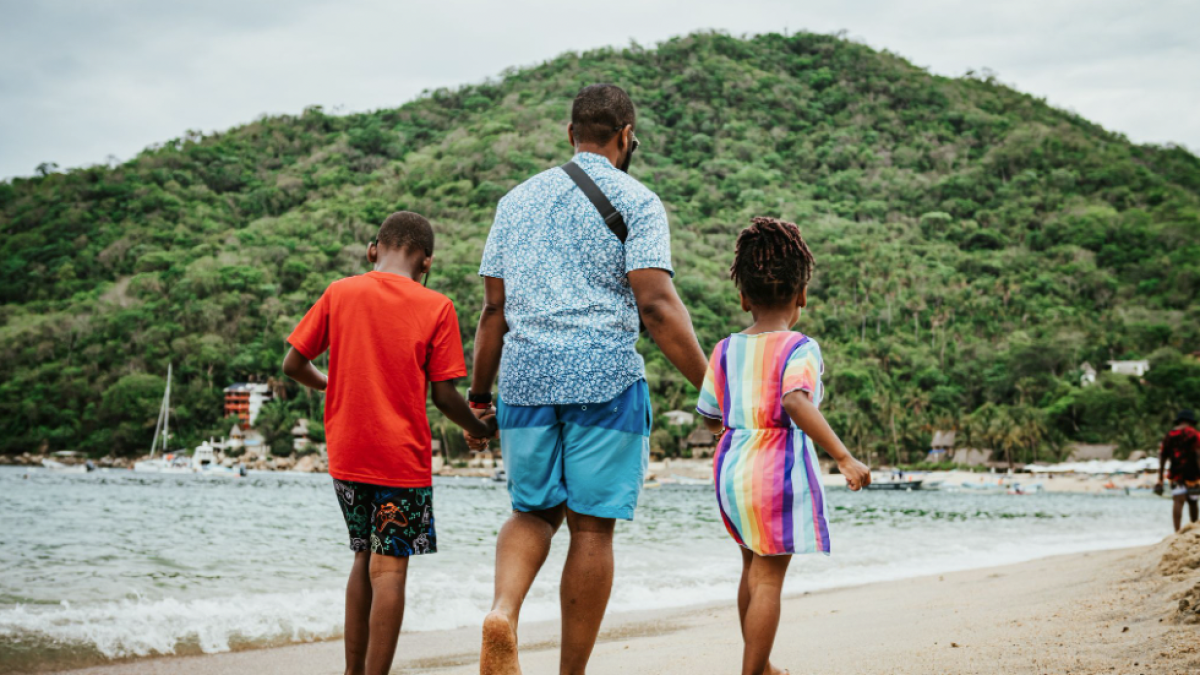 a group of people standing on top of a sandy beach