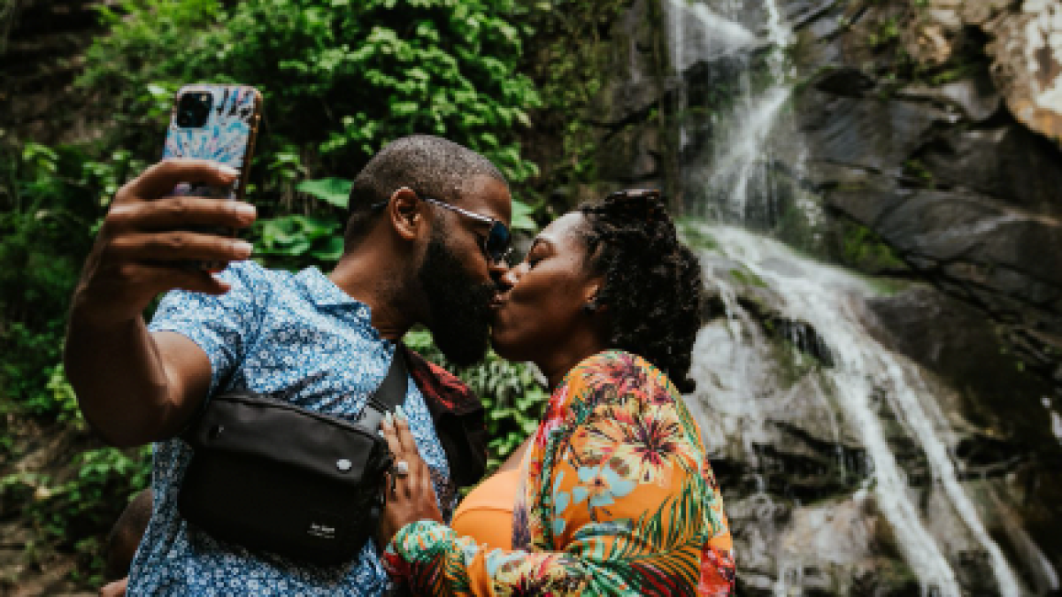 a group of people standing next to a waterfall