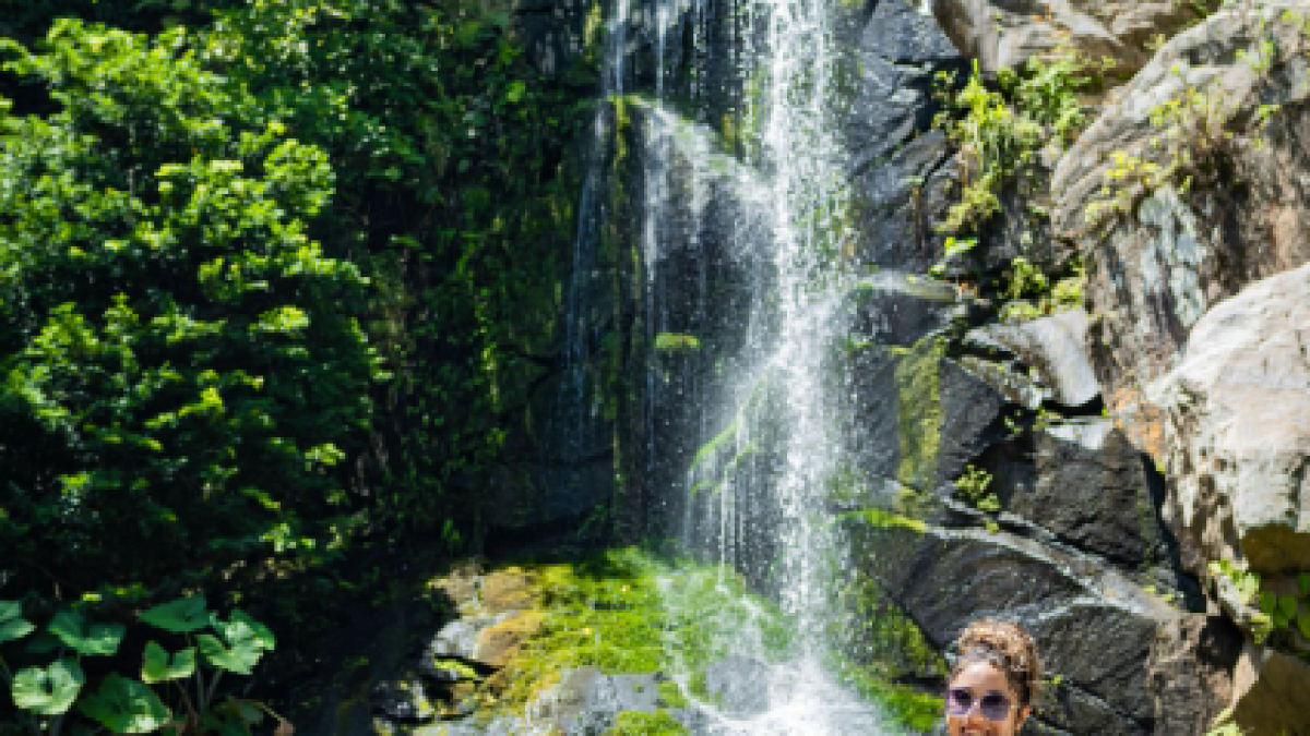 a man standing next to a waterfall