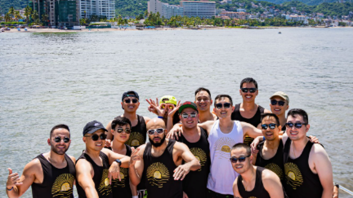 a group of people standing next to a body of water
