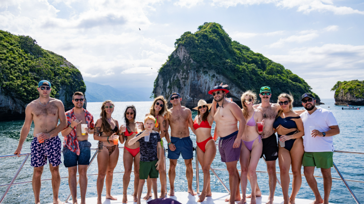 a group of people standing on a beach posing for the camera