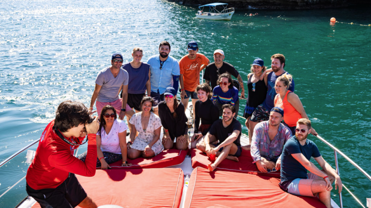a group of people sitting next to a body of water