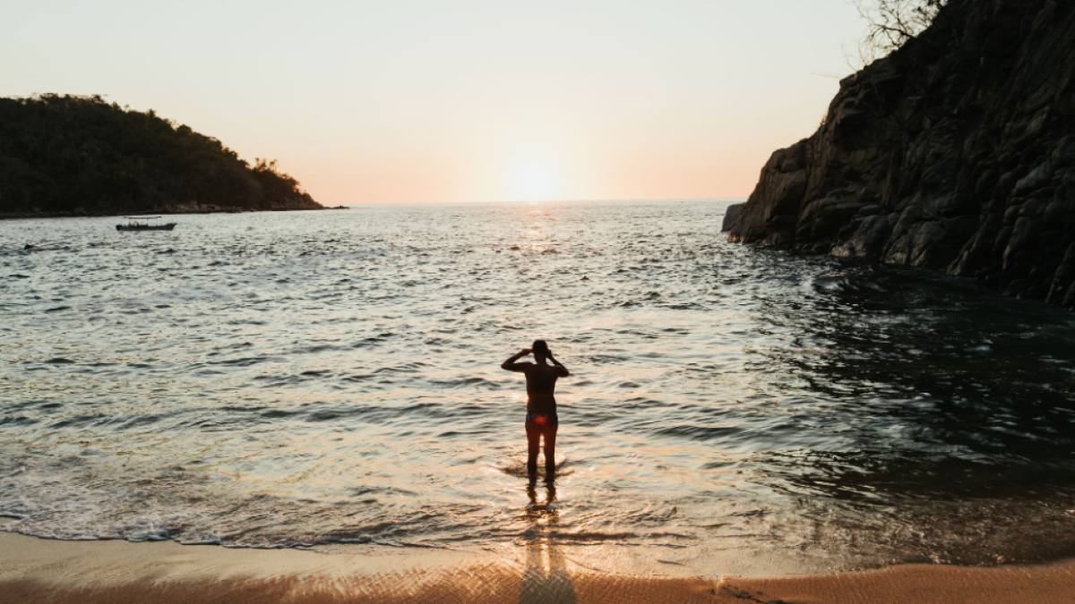 a man standing on a beach near a body of water