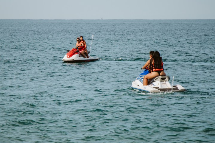 a group of people riding on the back of a boat in the water