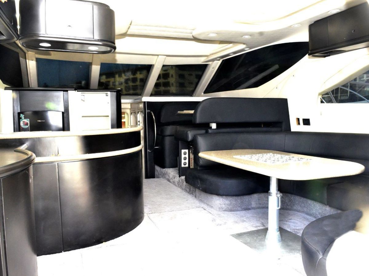 Luxury yacht interior with black leather seating and dining area.