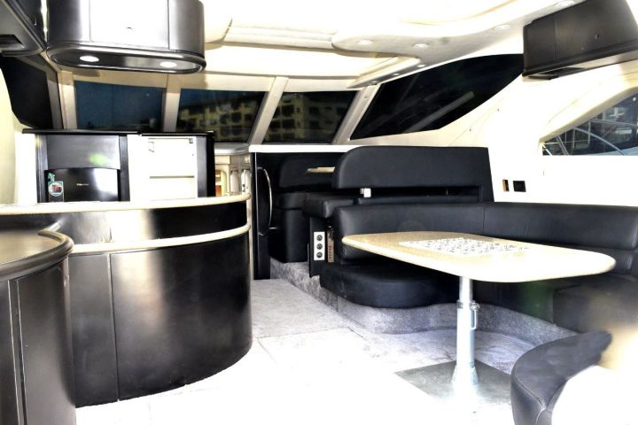 Luxury yacht interior with black leather seating and dining area.