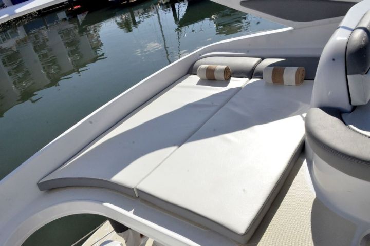 Boat sun deck with cushions and water view.