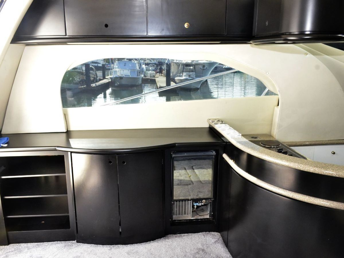 Interior boat view with black cabinets and large window overlooking marina.