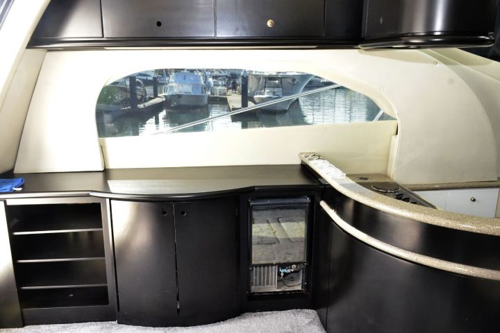Interior boat view with black cabinets and large window overlooking marina.