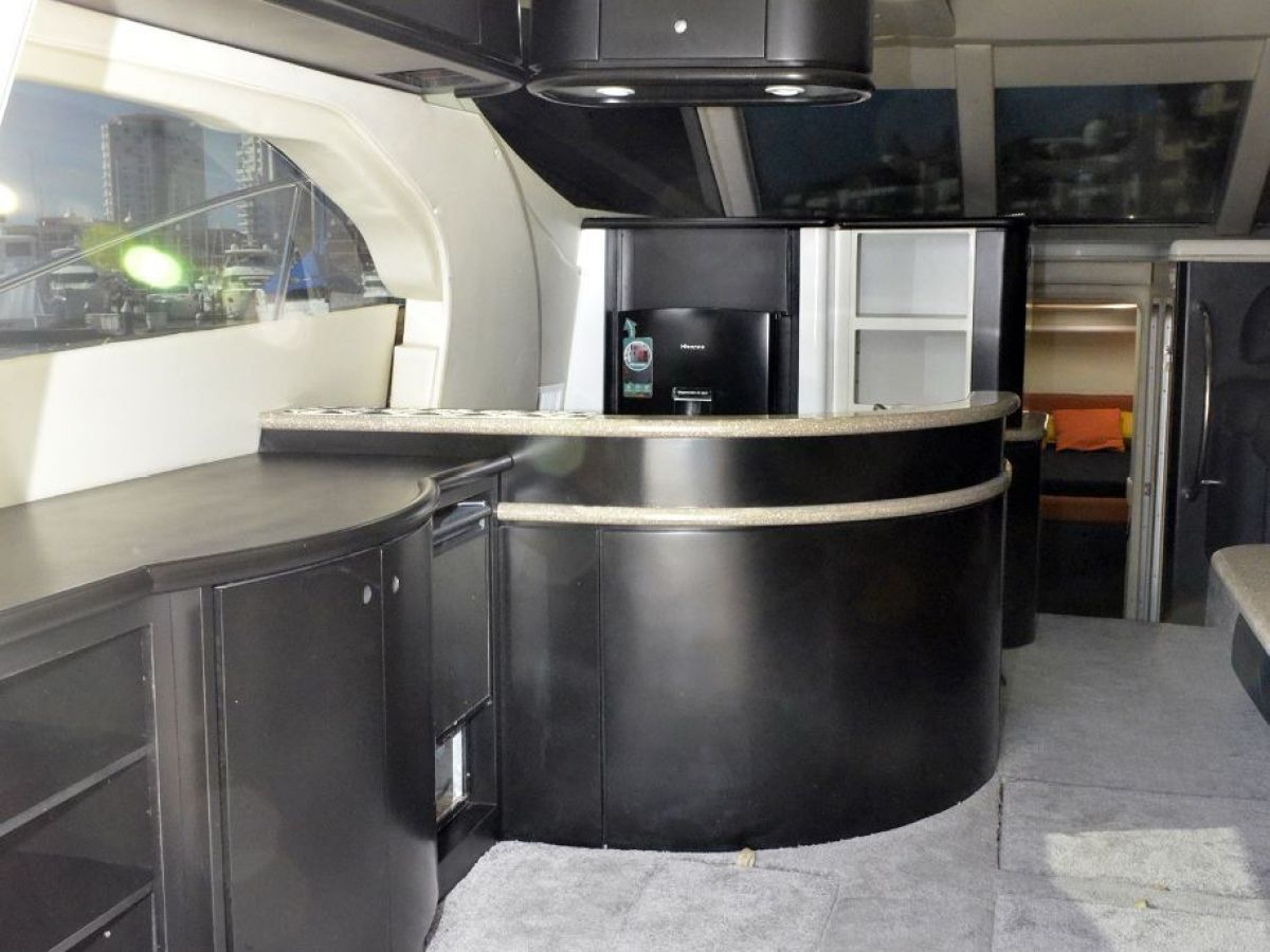 Modern yacht interior with sleek black furnishings and carpeted flooring.