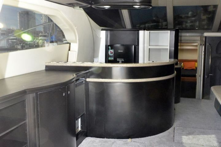 Modern yacht interior with sleek black furnishings and carpeted flooring.