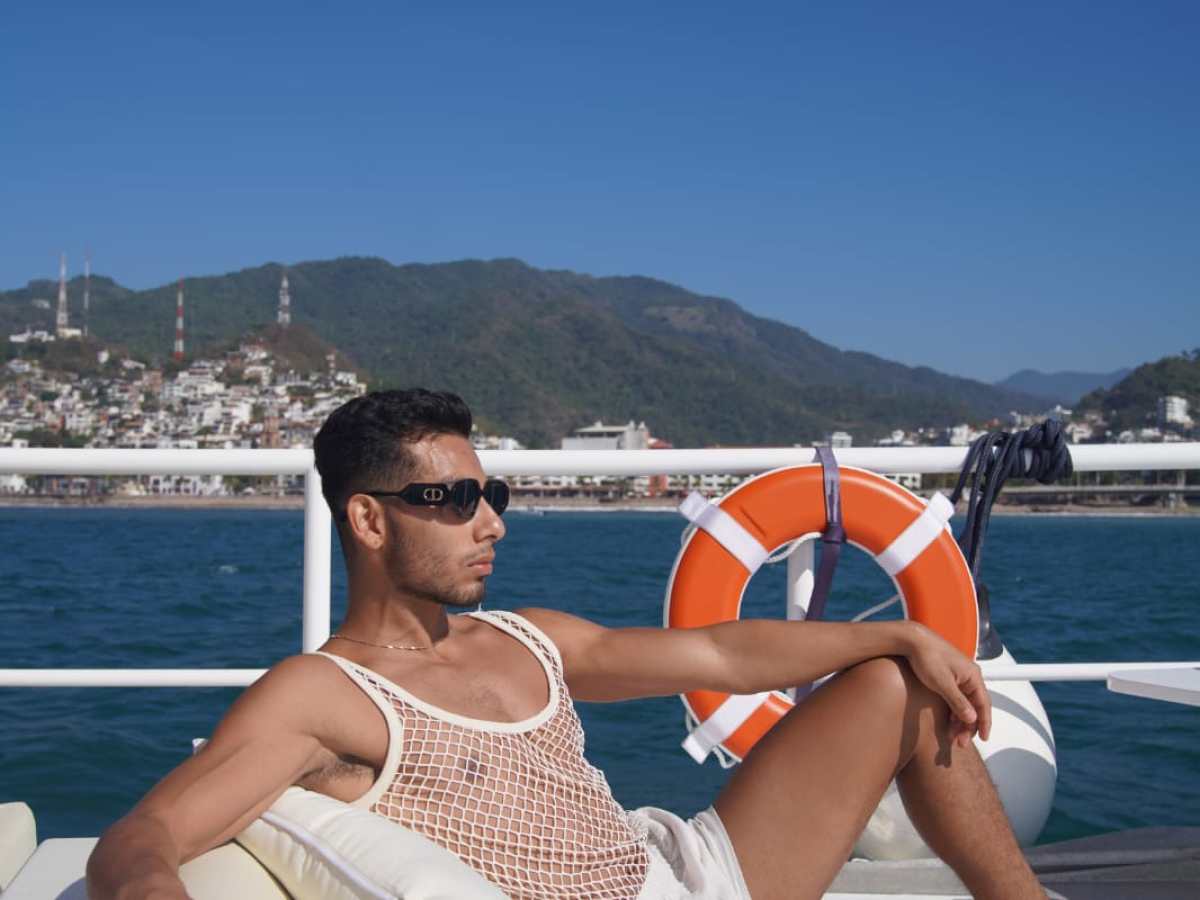 a group of people sitting at a beach umbrella in the sand