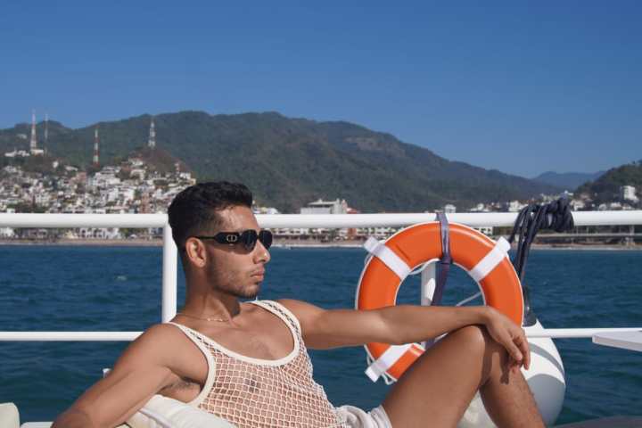 a group of people sitting at a beach umbrella in the sand