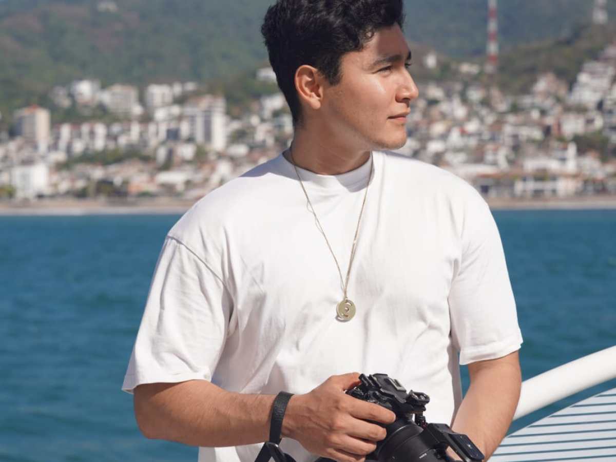 a man standing next to a body of water