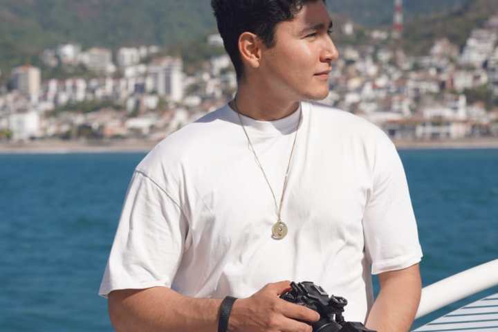 a man standing next to a body of water