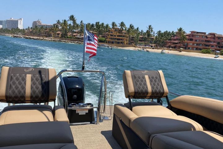 a chair next to a body of water with a city in the background