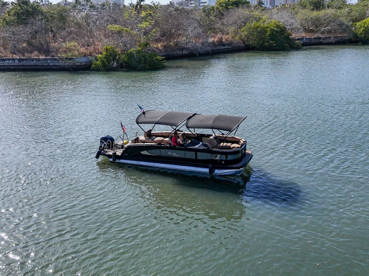 a boat floating along a river next to a body of water