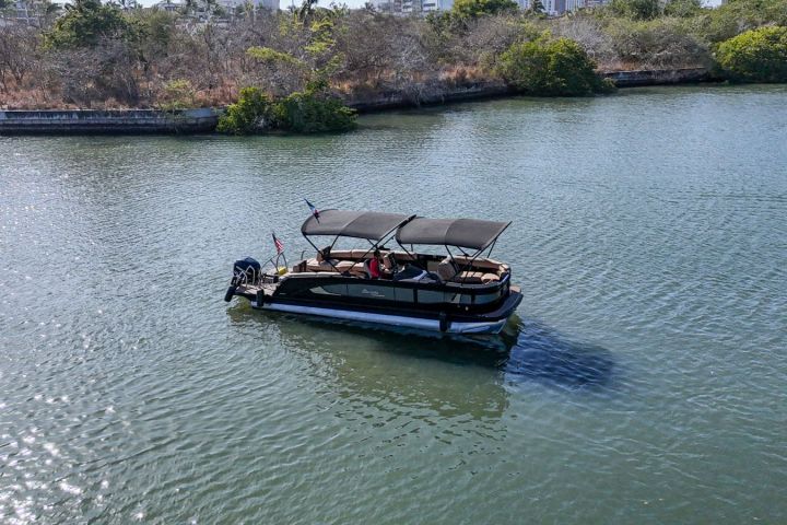 a boat floating along a river next to a body of water
