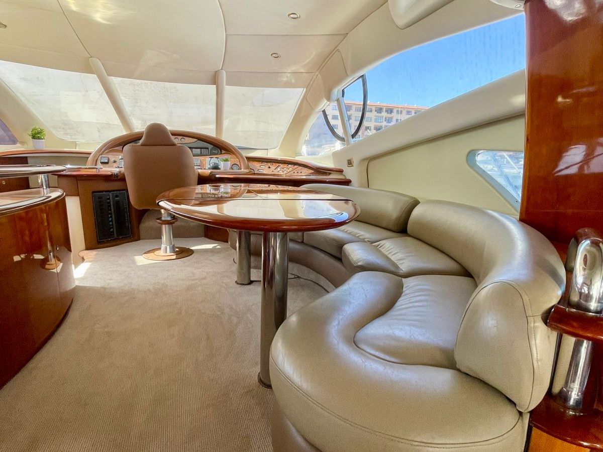 Luxurious yacht interior with curved leather seating and wooden accents.