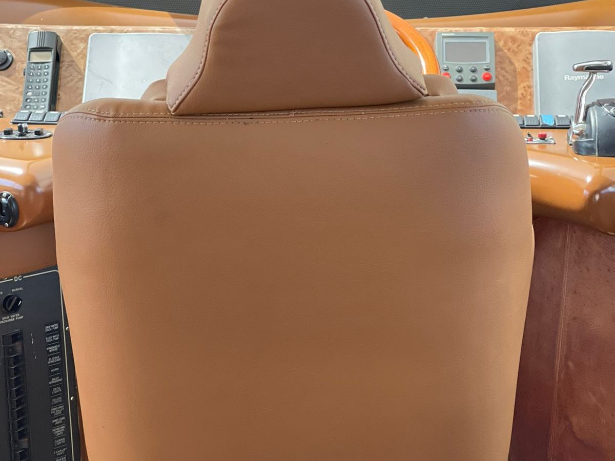 Brown leather chair in front of a yacht control panel.