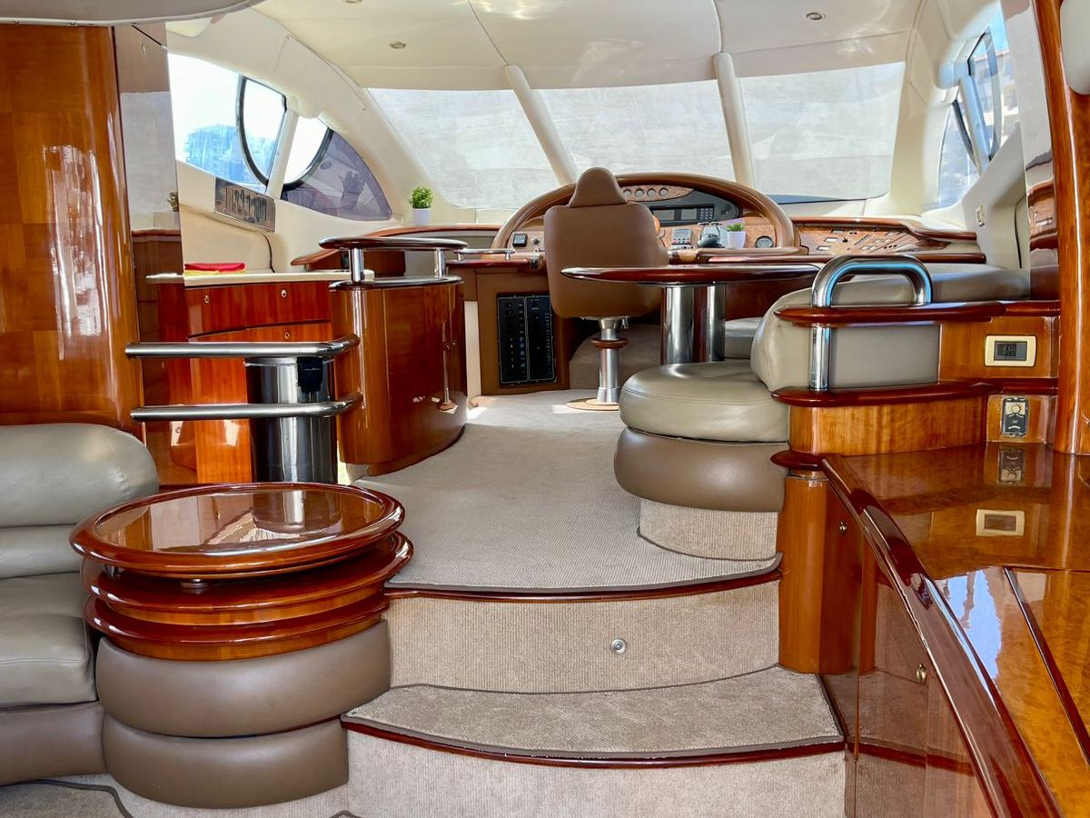 Luxurious yacht interior with wood finishes, steps, and a steering wheel.