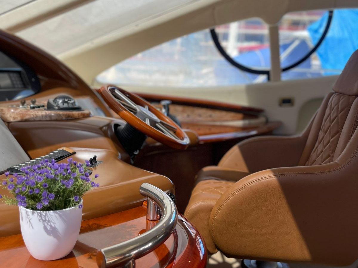 Luxurious yacht interior with leather seat and potted plant.