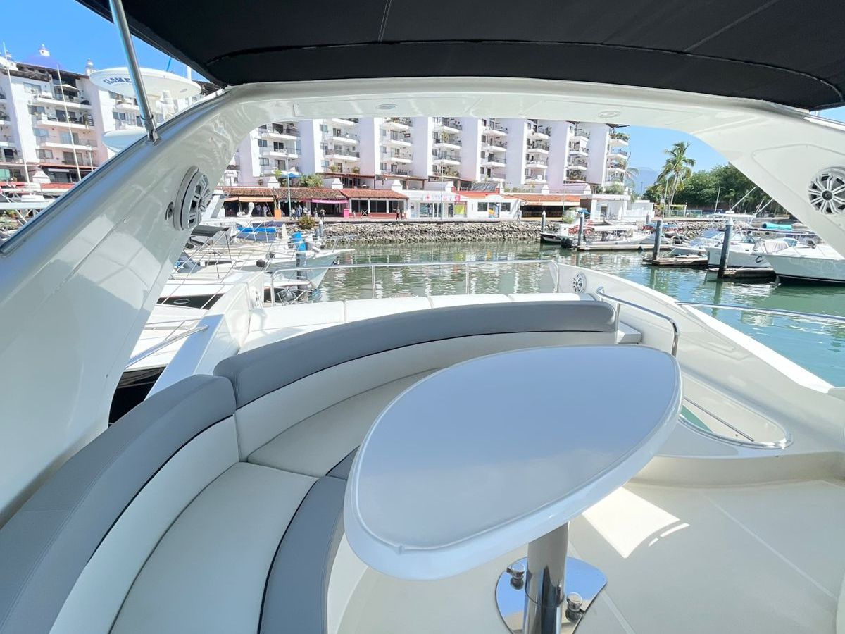 View from a yacht's deck with a circular table and marina in the background.
